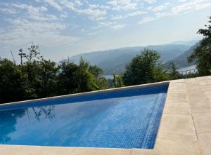 a swimming pool with a view of the mountains at Assossego House - Gerês in Geres
