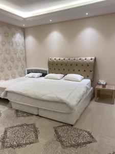 1 dormitorio con 1 cama blanca grande y cabecero en The Fort Farm en Suḩaybah