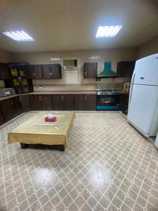 a large kitchen with a table and a refrigerator at The Fort Farm in Suḩaybah