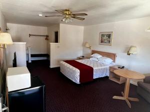 Rodeway Inn - Santa Fe Inn في وينيموكا: غرفة الفندق بسرير وطاولة