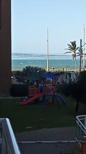 un parque infantil en la playa con el océano en el fondo en Temporada VG FUN Fortaleza CE, en Fortaleza