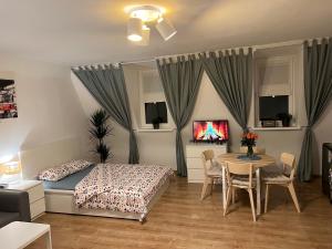 una camera con letto, tavolo e sedie di Grand Central Apartments a Katowice