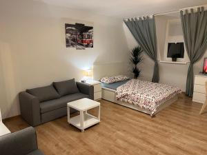 un soggiorno con letto e divano di Grand Central Apartments a Katowice