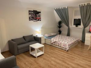 a living room with a bed and a couch at Grand Central Apartments in Katowice