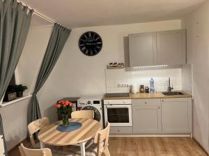una cocina con mesa y una pequeña cocina con reloj en Grand Central Apartments, en Katowice