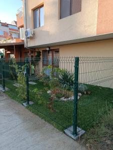 a green fence in front of a house at Megi Apartments, Nesebar sity in Nesebar