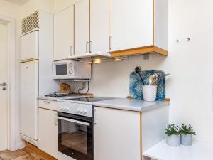 a kitchen with white cabinets and a stove top oven at 7 person holiday home in Brenderup Fyn in Bro