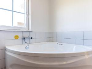 W łazience z oknem znajduje się biała wanna. w obiekcie 7 person holiday home in Brenderup Fyn w mieście Bro