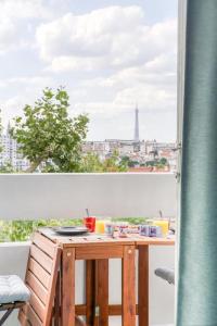 una mesa con vistas a la ciudad desde una ventana en Super appartement avec vue sur la Tour Eiffel, en Le Kremlin-Bicêtre 6 fotos más