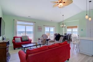 a living room with red furniture and a dining room at Minty Escape in North Topsail Beach