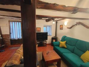 a living room with a green couch and a tv at Casa Rural Sarrion in Teruel