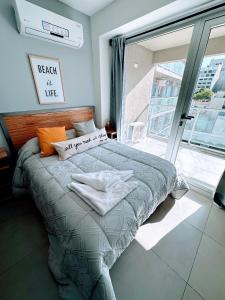 łóżko w pokoju z dużym oknem w obiekcie Palermo Medrano Studio Suits w BuenosAires