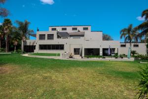 a large white house with a lawn in front of it at Fair Glen in Kyalami