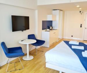 a bedroom with a bed and two chairs and a table at ORBY CITY HOTEL 5* in Batumi