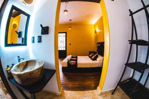 a bathroom with a tub and a bedroom with a bed at Niyana Oaxaca in Oaxaca City