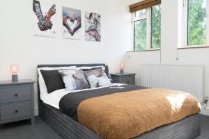 a bedroom with a bed with two night stands and two windows at Amazing Apt with 2 bathrooms close to Battersea Park in London