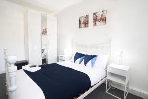 a white bedroom with a blue and white bed at Amazing Apt with 2 bathrooms close to Battersea Park in London