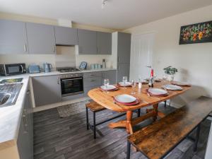 een keuken met een houten tafel met stoelen en een eetkamer bij 23 Moat House Close in Coventry