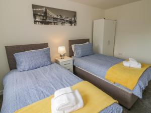 a bedroom with two beds and a mirror at 23 Moat House Close in Coventry