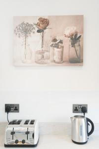 a counter with a toaster and flowers in glass vases at Amazing Apt with 2 bathrooms close to Battersea Park in London