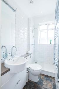 a white bathroom with a sink and a toilet at Amazing Apt with 2 bathrooms close to Battersea Park in London