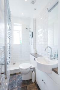 a white bathroom with a toilet and a sink at Amazing Apt with 2 bathrooms close to Battersea Park in London