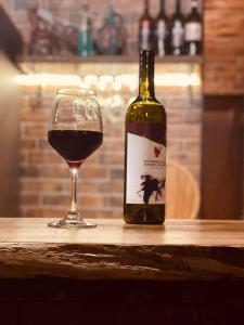 a bottle of wine and a glass on a table at odahouse. fireplace and spring water. in Batumi +37 photos