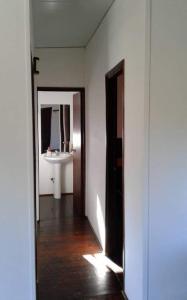 a hallway with a bathroom with a sink and a mirror at MZion in Piriápolis