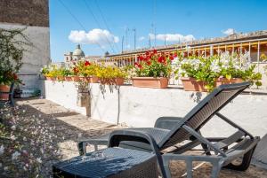 uma cadeira sentada numa varanda com flores em Il Garbino Suite and Apartment em Lecce