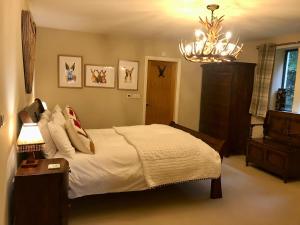 um quarto com uma cama e um lustre em The Haven em Barlow