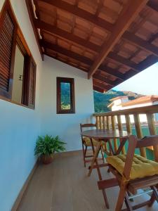 a patio with a wooden table and chairs at Caminho da areia in Ubatuba