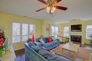 a living room with a blue couch and a ceiling fan at Surf and Sound in North Topsail Beach