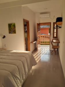 Schlafzimmer mit einem Bett und Blick auf einen Balkon in der Unterkunft Caminho da areia in Ubatuba