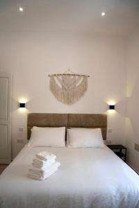 Un dormitorio con una cama blanca con toallas. en The Olive 3 - Traditional Maltese Accommodation, en Birgu