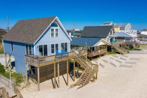 une maison bleue sur la plage avec des escaliers menant à celle-ci dans l'établissement Perfect Prescription, à Surf City