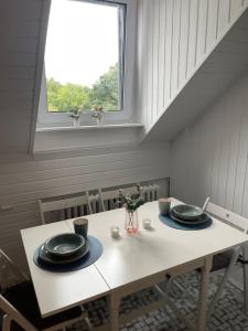 a dining room table with two plates and a window at Riverside attic apartment near the Chocolate Museum in Cologne