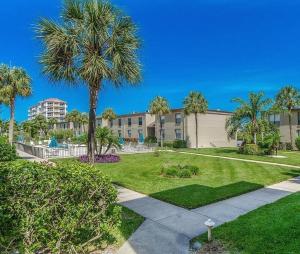 un parque con palmeras y un edificio en Sea Club Condo #47, en Clearwater Beach