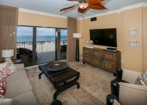 a living room with a couch and a flat screen tv at The Palms 313A in Orange Beach