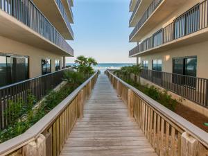 a boardwalk leading to the beach from a building at The Palms 313A in Orange Beach