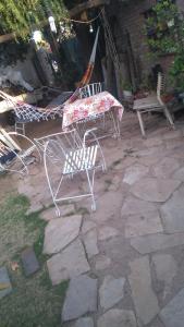 two chairs and a table on a stone patio at HOSTEL ATG in Ciudad Lujan de Cuyo