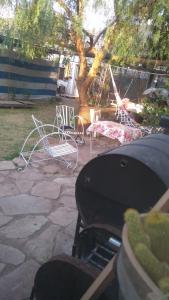 a patio with chairs and a table and a grill at HOSTEL ATG in Ciudad Lujan de Cuyo