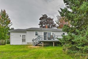 una casa blanca con terraza en el patio en Cottage 3 Miles to Dwntwn and Bangor Waterfront 