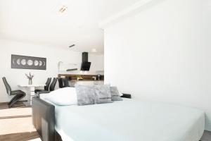 een witte slaapkamer met een bed en een tafel bij Baltic Seaside in Sierksdorf