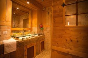 a bathroom with a sink and a large mirror at Logis hôtel Arbez Franco Suisse in Les Rousses