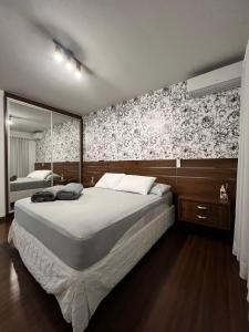sypialnia z dużym łóżkiem i lustrem w obiekcie Pousada Central Jaraguá w mieście Jaraguá do Sul