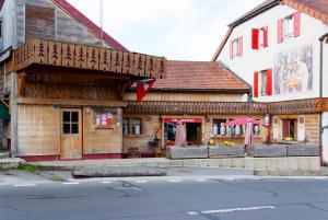 a wooden building on the side of a street at Logis hôtel Arbez Franco Suisse in Les Rousses