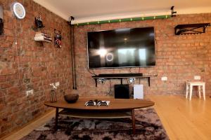 a brick wall with a large tv on a wall at Mini cinema & movie studio with PS5 in Rīga