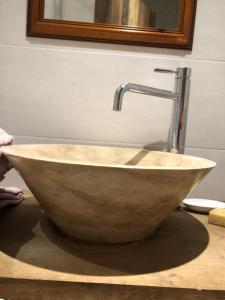 La salle de bains est pourvue d'un lavabo en pierre et d'un robinet. dans l'établissement LE CHALET de la goutte, à Saint-Appolinaire