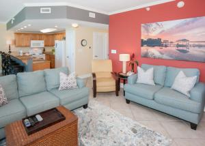 sala de estar con 2 sofás azules y cocina en Sanibel 307, en Gulf Shores