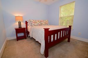 a bedroom with a bed and a lamp and a window at Porch Lane Cottage C in Fairhope
